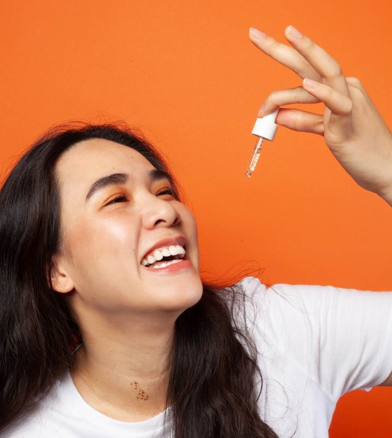 Portrait femme souriant prenant de l'huile de CBD 15% Equilibre