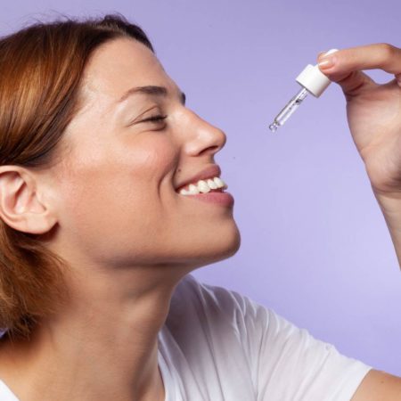 Portrait femme souriant prenant de l'huile de CBD 10% Equilibre