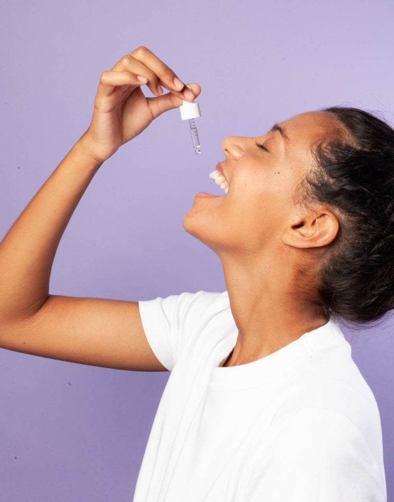 Portrait femme souriant prenant de l'huile de CBD 5% Equilibre