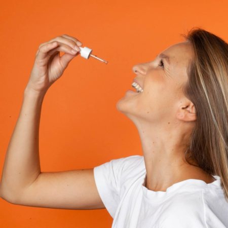 Portrait femme souriant prenant de l'huile de CBD 10% Equilibre